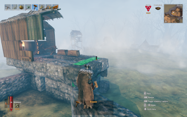 Player character building up a wooden walls on top of a stone tower.